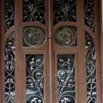 Puerta de madera con enrejado de hierro forjado