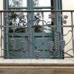Barandilla de hierro del balcón corrido del primer piso, forjada con motivos vegetales (racimos de uvas) y sinuosidades (2)