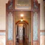 Puerta-cristalera interior, con el nombre del edifici en el montante